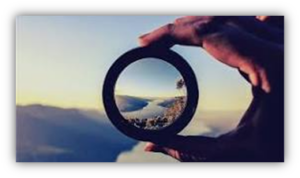 Photographer hand holds a protective filter from the lens, against the backdrop of a beautiful mountain landscape